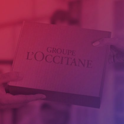 Imagem de duas mãos passando uma caixa com o logo do Groupe L'occitane