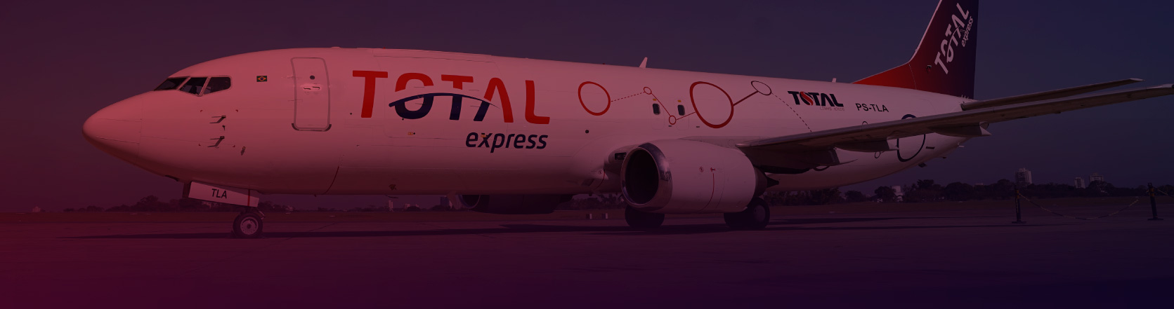Foto lateral de um avião com o logotipo da Total Express estampado por toda a lataria.